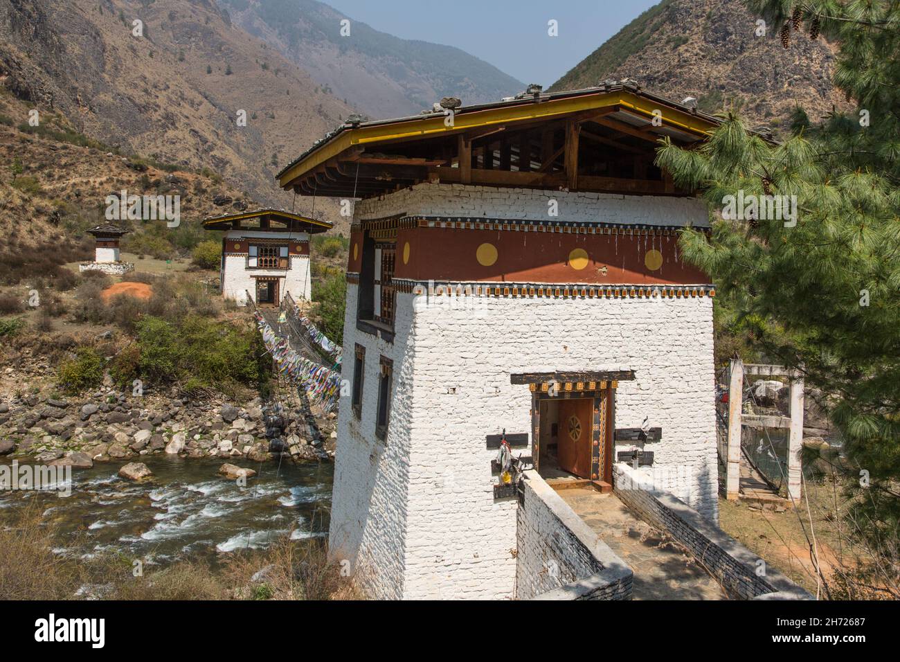 Bandiere di preghiera fianeggiano l'ultimo ponte di ferro rimasto in Bhutan sul fiume Paro Chhu vicino a Paro, Bhutan. Foto Stock