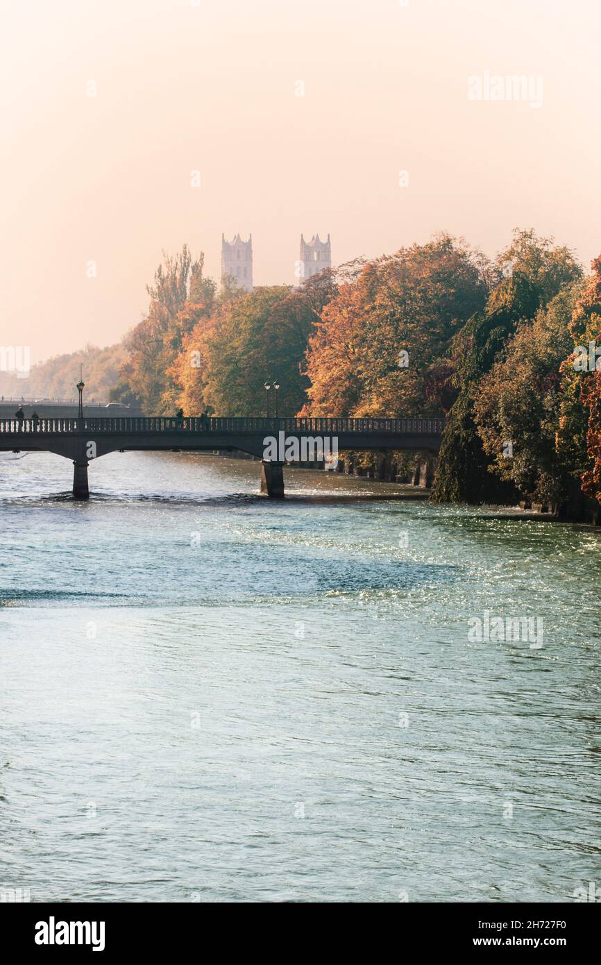 Monaco, ponte Bosch sul fiume Isar con le torri della chiesa di San Massimiliano, vista autunnale in una giornata di nebbia soleggiata Foto Stock