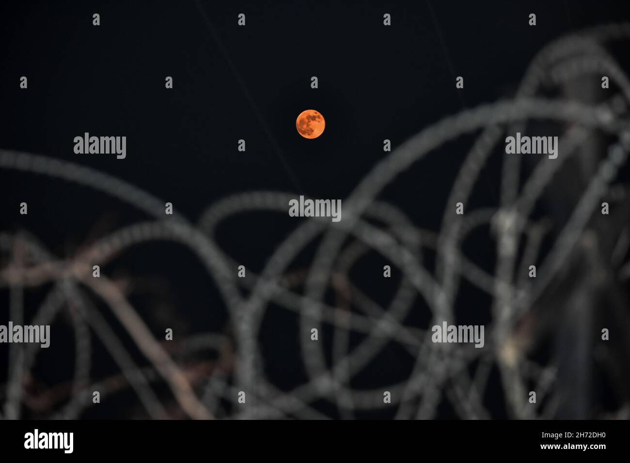 Srinagar, India. 19 Nov 2021. La luna di sangue vista sulla città di Kashmir di notte. La Luna sta per cadere nell'ombra della Terra per la durata più lunga dal 15 ° secolo, offrendo agli astronomi un'opportunità unica di osservare un'eclissi lunare. (Foto di Saqib Majeed/SOPA Images/Sipa USA) Credit: Sipa USA/Alamy Live News Foto Stock