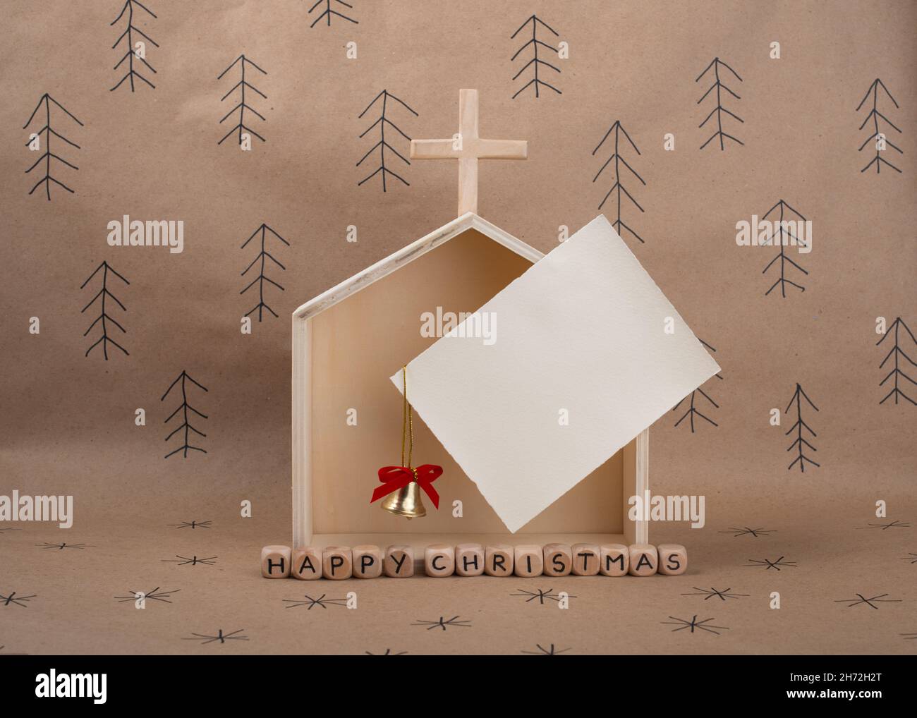 Chiesa in legno fatta a mano e carta bianca con spazio per l'invito o il saluto. Concetto minimo eco Natale. Foto Stock