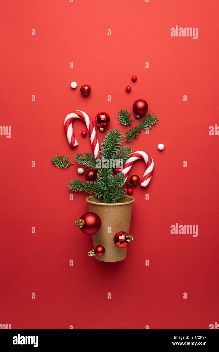 Biglietto di Natale con ornamenti natalizi e canne di caramelle su sfondo rosso Foto Stock