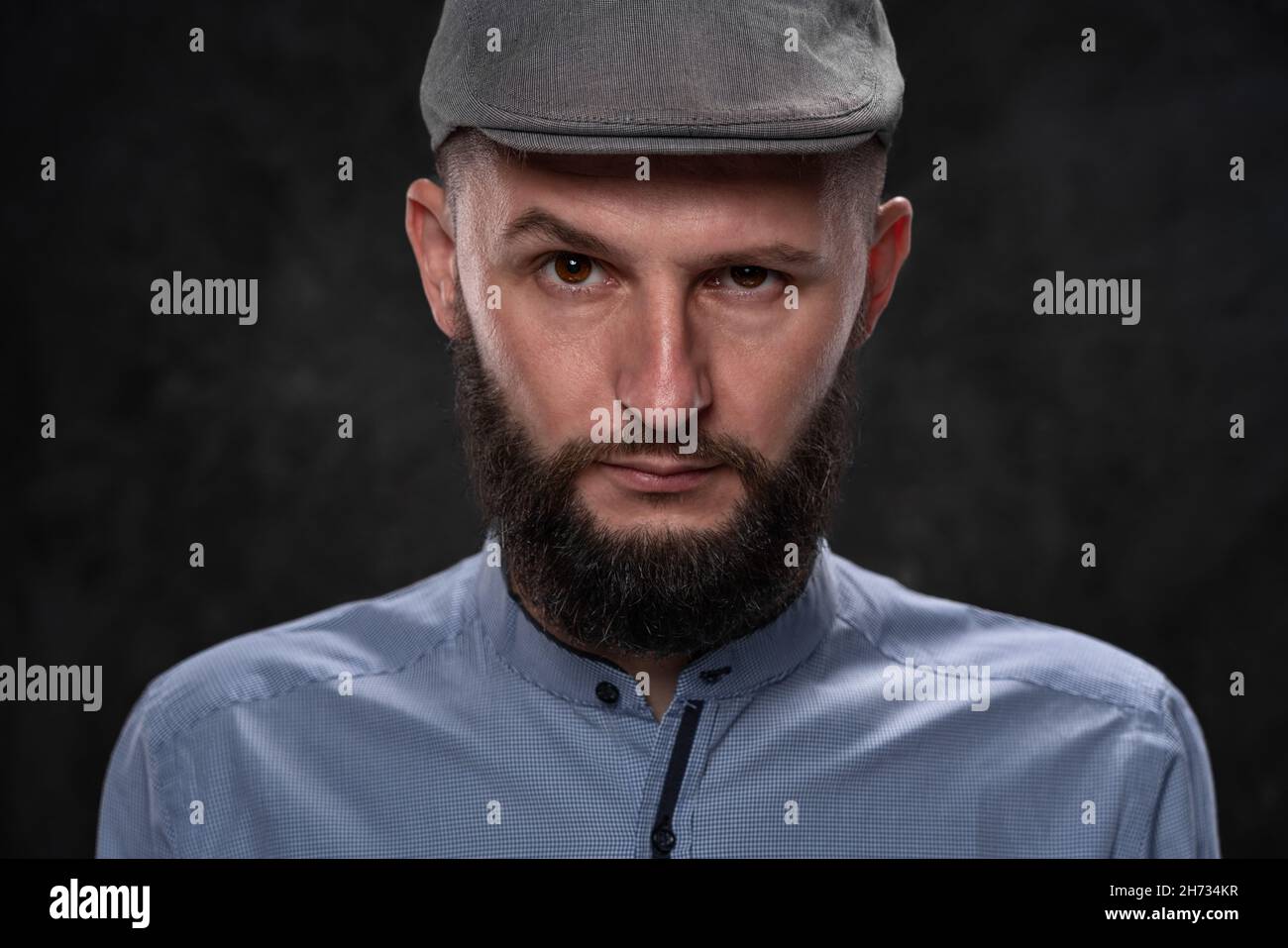 Un ragazzo, un uomo in una berretto, guarda avanti con uno sguardo severo e arrabbiato. Concetto del vincitore, primo piano. Foto Stock