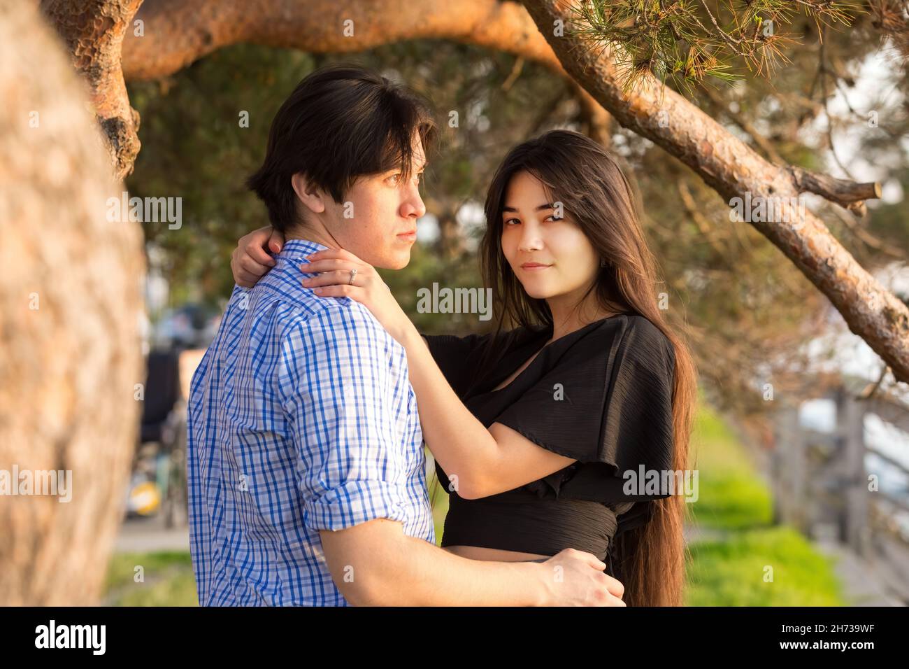 Goodlooking giovane biraciale asiatico caucasico misto coppia di corsa godendo insieme tempo dal lago al tramonto nel nord-ovest del Pacifico Foto Stock