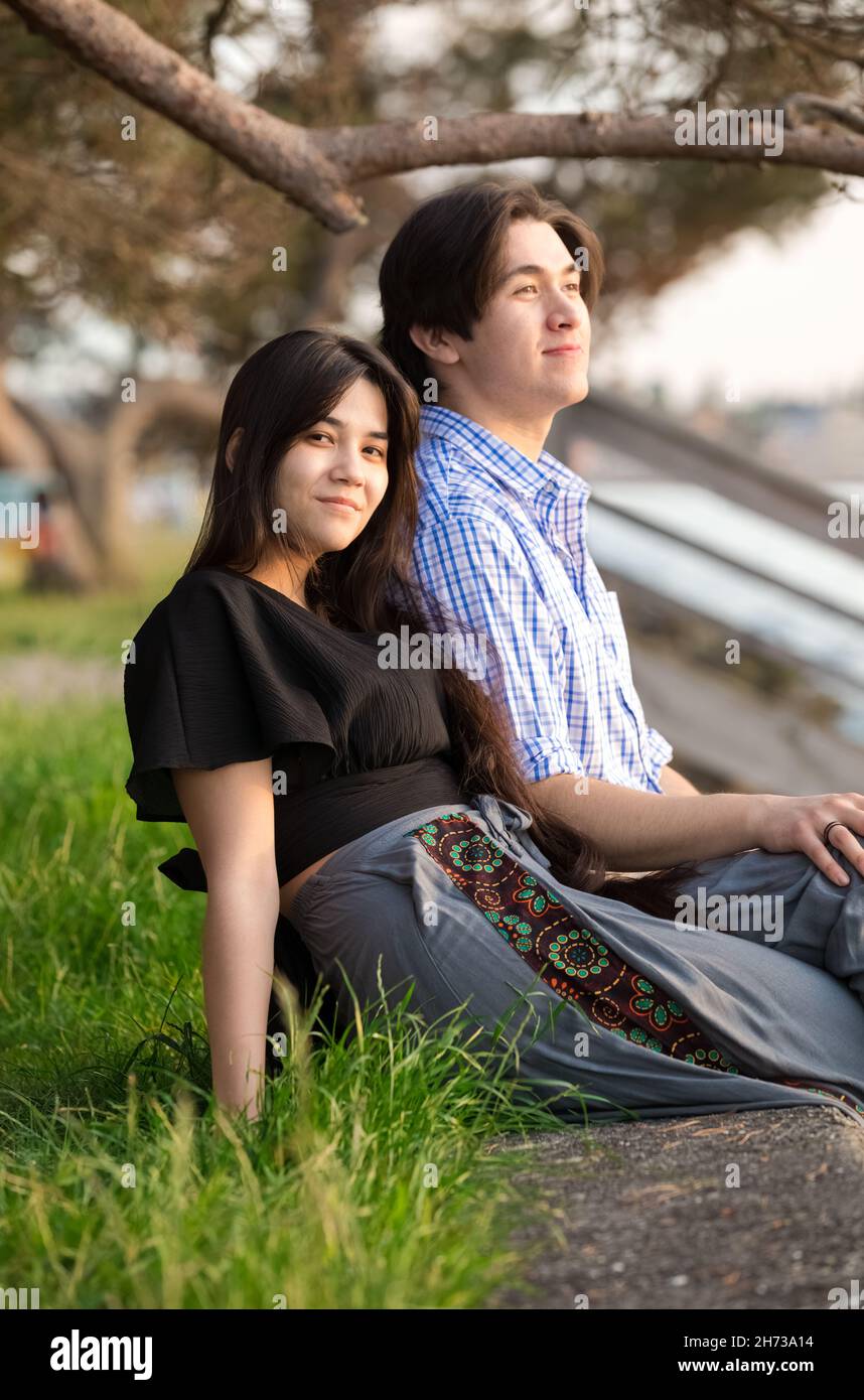 Goodlooking giovane biraciale asiatico caucasico misto coppia di corsa godendo insieme tempo dal lago al tramonto nel nord-ovest del Pacifico Foto Stock