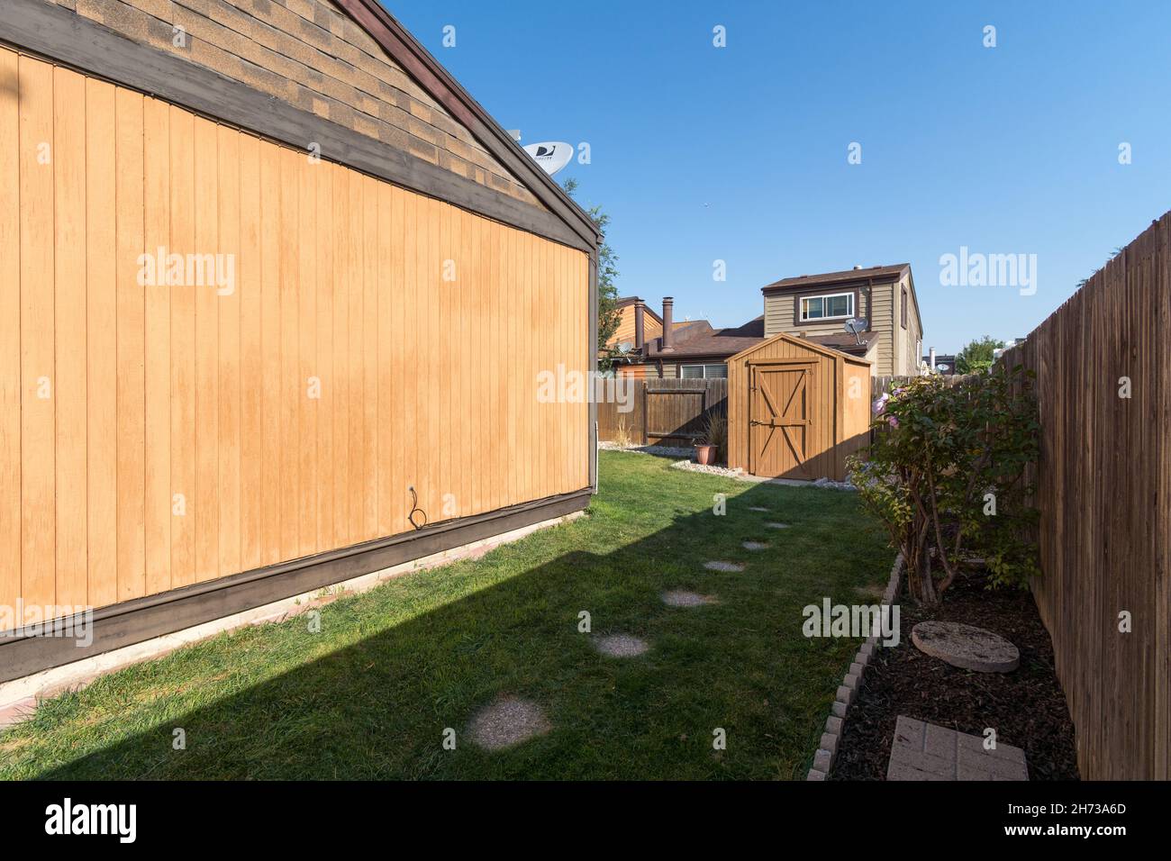 Grande casa di legno marrone con una piccola casa su erba verde lastricata Foto Stock