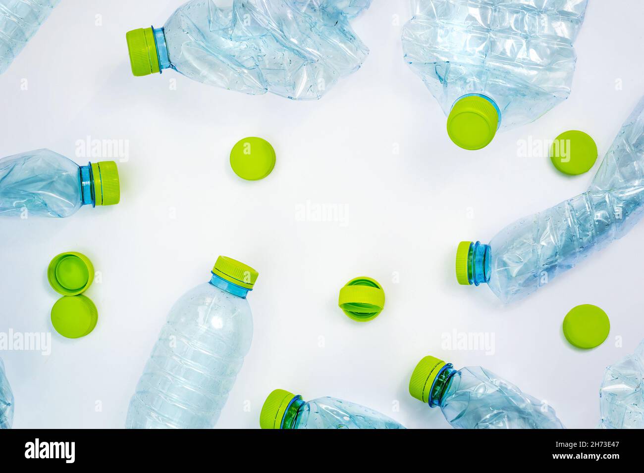 Bottiglie e tappi in plastica a posa piatta su sfondo bianco Foto Stock