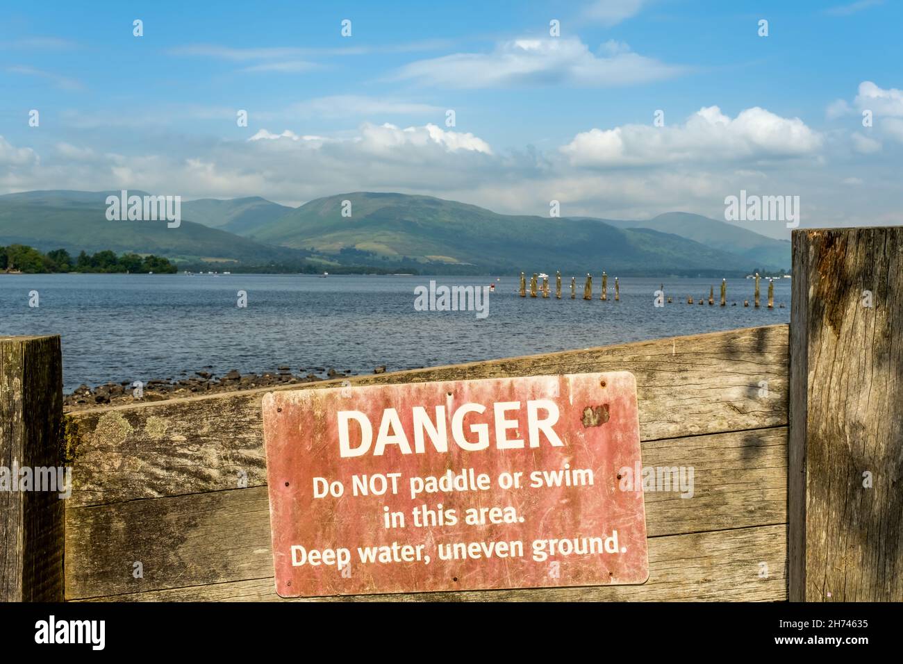 Un vecchio pericolo rosso, non pagaiare o nuotare cartello di avvertimento a Loch Lomond, Scozia Foto Stock