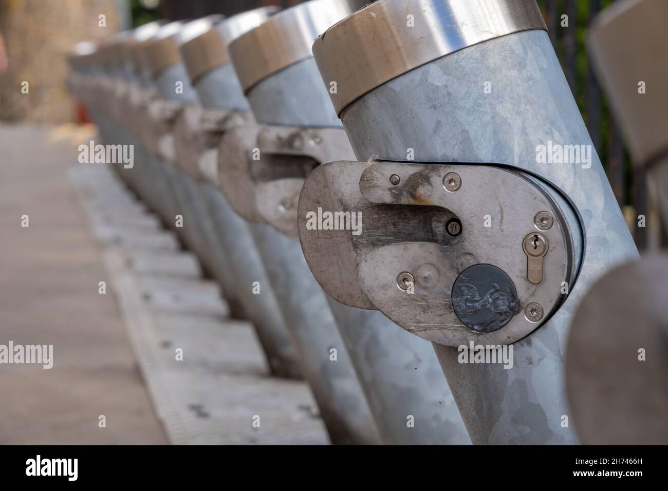 Primo piano di una fila di numerose stazioni condivise per biciclette vuote Foto Stock
