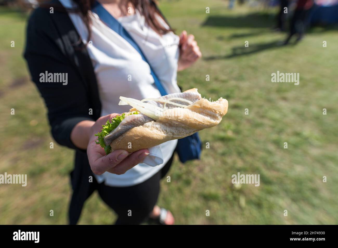 Donna che tiene il rotolo di pesce in mano Foto Stock