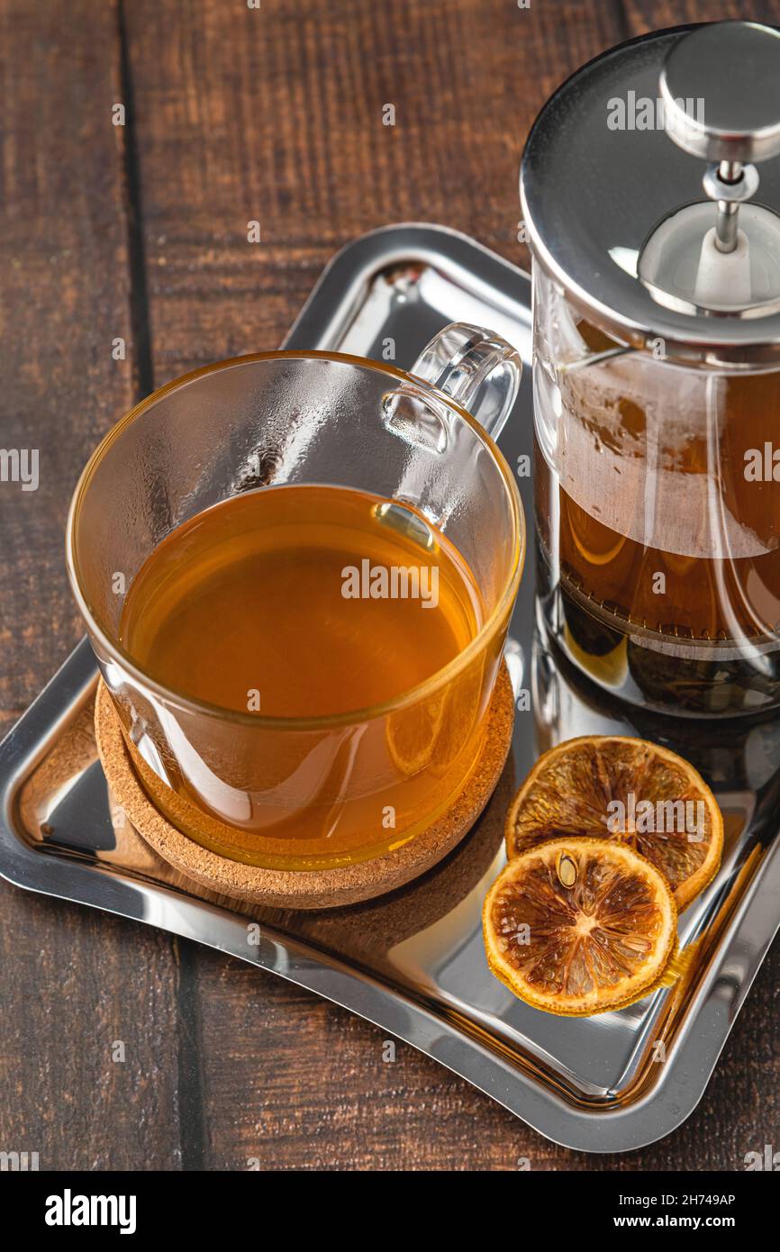 Caldo tè invernale servito con una pressa francese su un pavimento in legno. Foto Stock