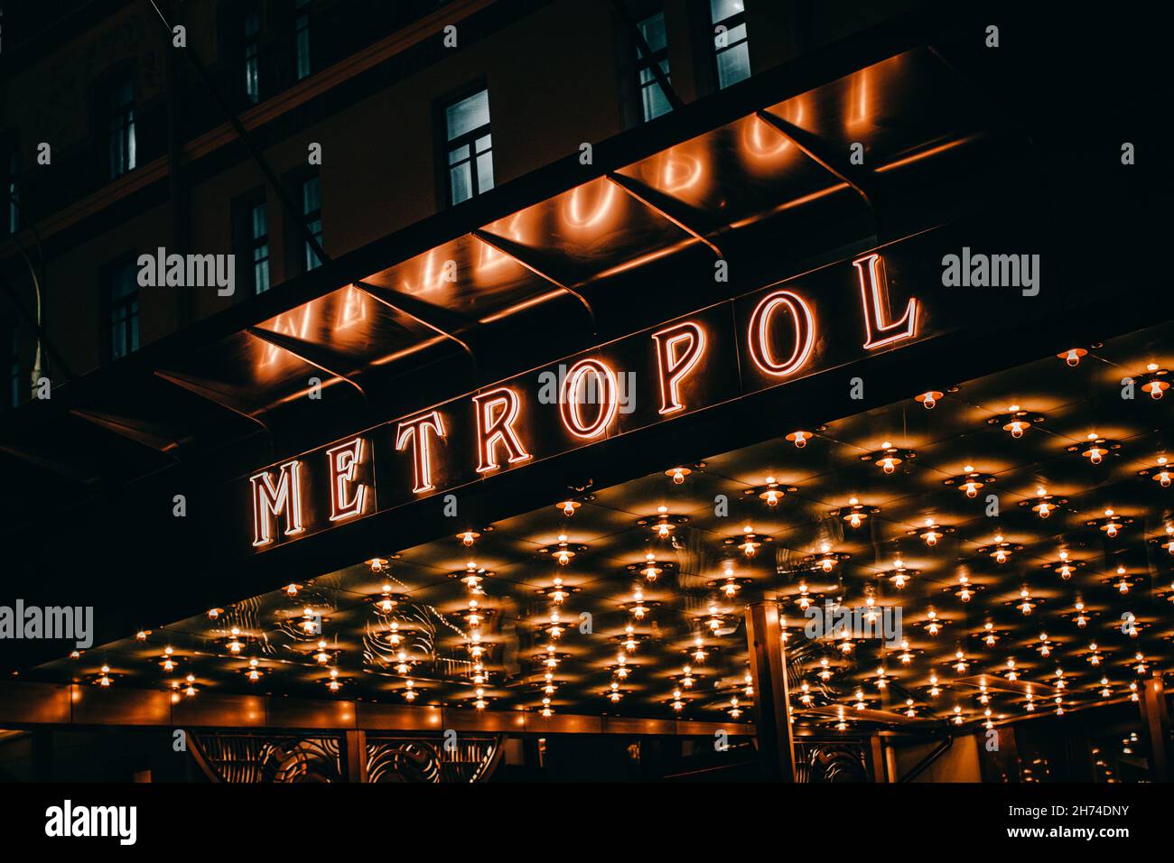 Luminoso logo dorato del lussuoso hotel Metropol di Mosca, Russia. Luci serali e architettura storica del famoso edificio Foto Stock