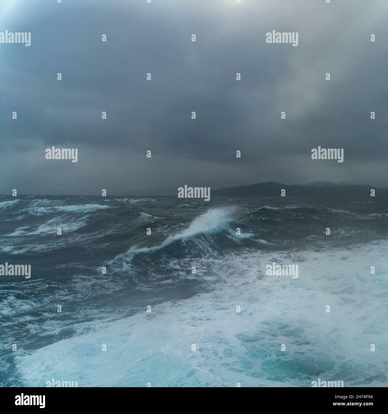 Wellen auf der Reise mit dem Schiff zum Nordkap, Norwegen. Sturm auf dem Atlantik mit Schaumkronen auf den Wellen und Gischt auf dem Schiff. Wolken Foto Stock