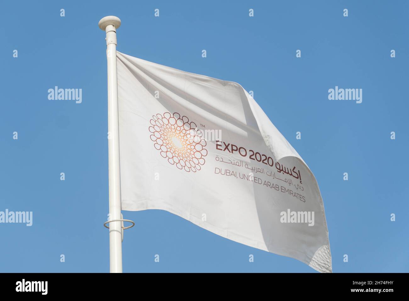 '11.19.2021 - Dubai, Emirati Arabi Uniti - White Expo 2020 Bandiera che soffia nel vento sul cielo blu a Dubai per la Fiera Mondiale che mostra innovazione e sostenibilità Foto Stock