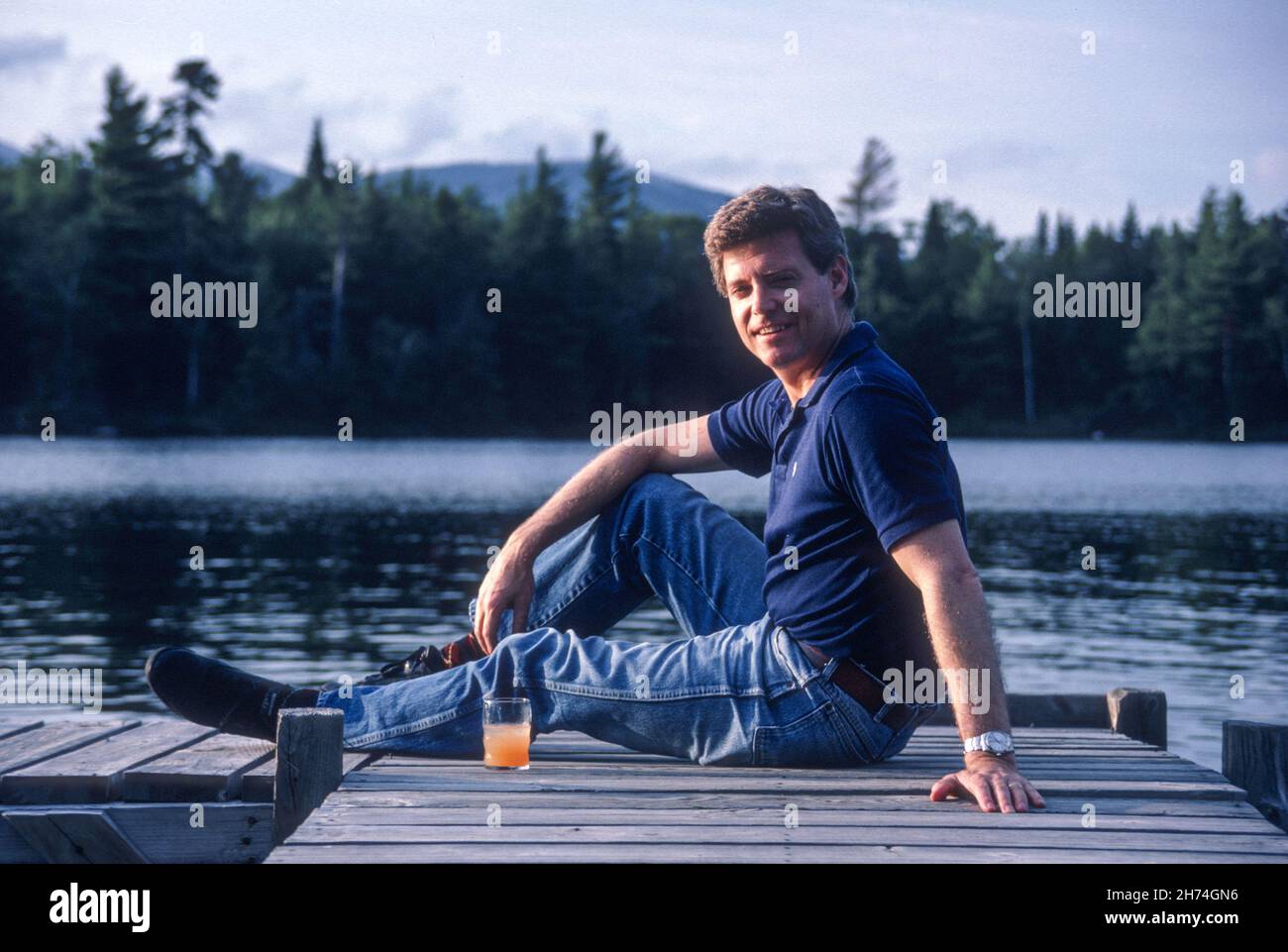 L'uomo vecchio di 39 anni siede su un molo a Lake Placid, 1987, NY, USA Foto Stock