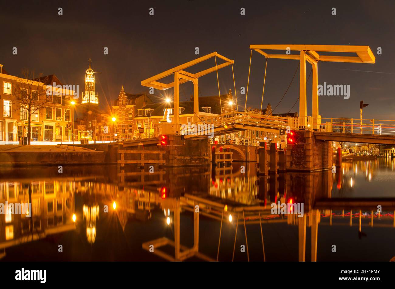 Haarlem, Paesi Bassi, 19 novembre 2021: Ponte levatoio in legno che si riflette nel fiume Spaarne di notte Foto Stock