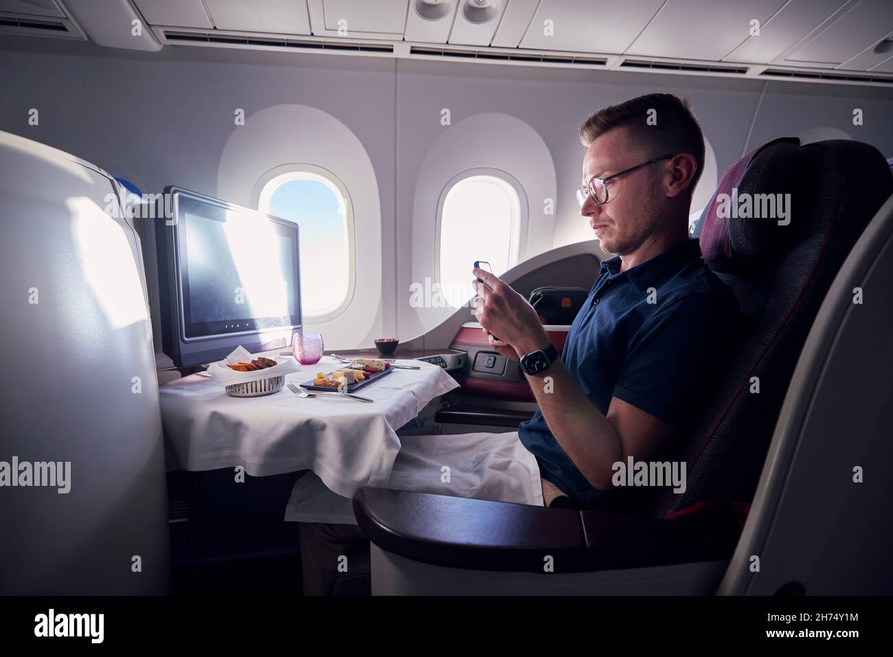 PRAGA, REPUBBLICA CECA - 2 SETTEMBRE 2021: Passeggeri che scattano foto del cibo durante il volo in business class in Qatar Airways Boeing 787-8 Dreamliner. Foto Stock