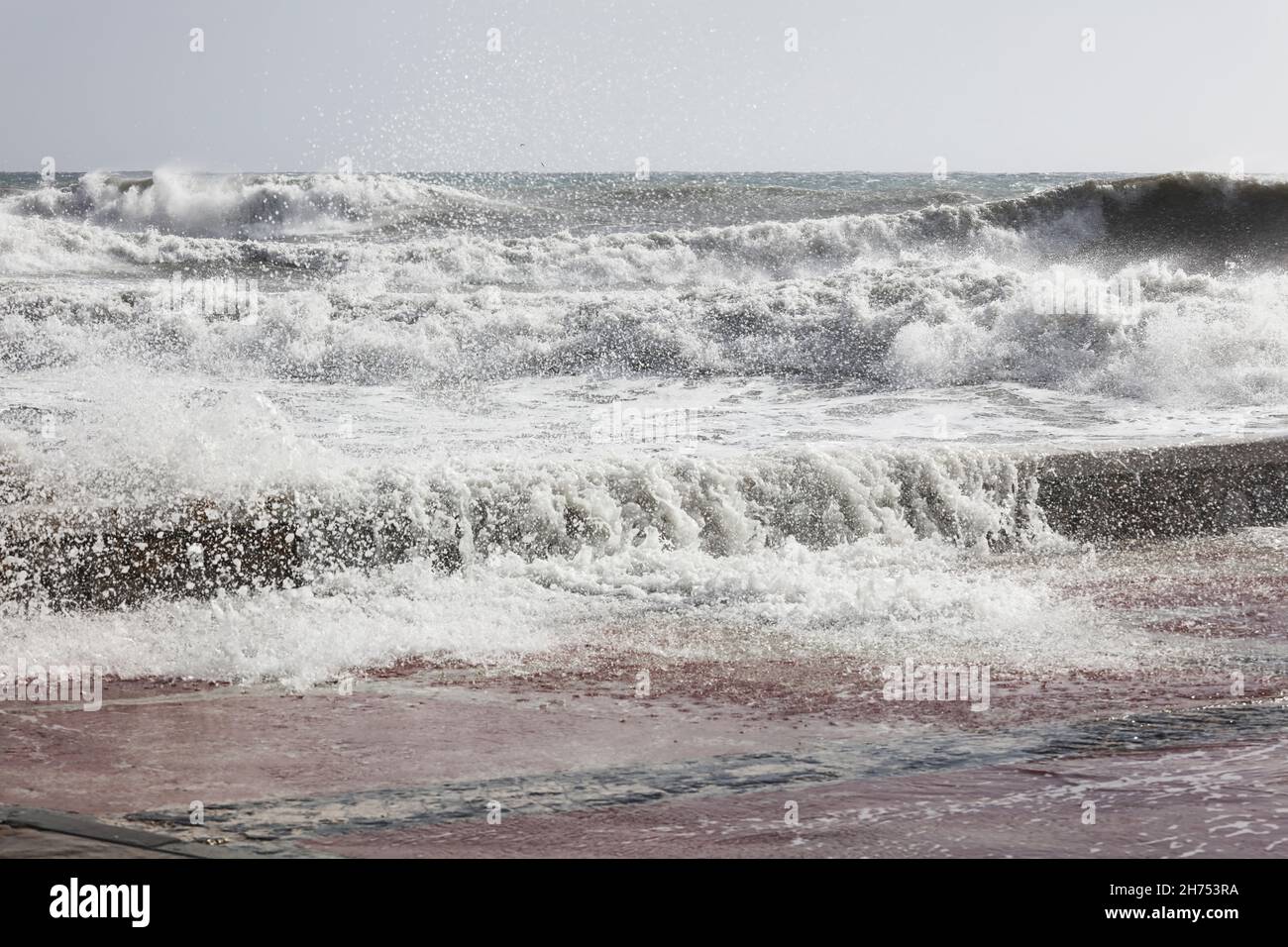 grandi onde che si infrangono sulla riva, con schiuma bianca Foto Stock
