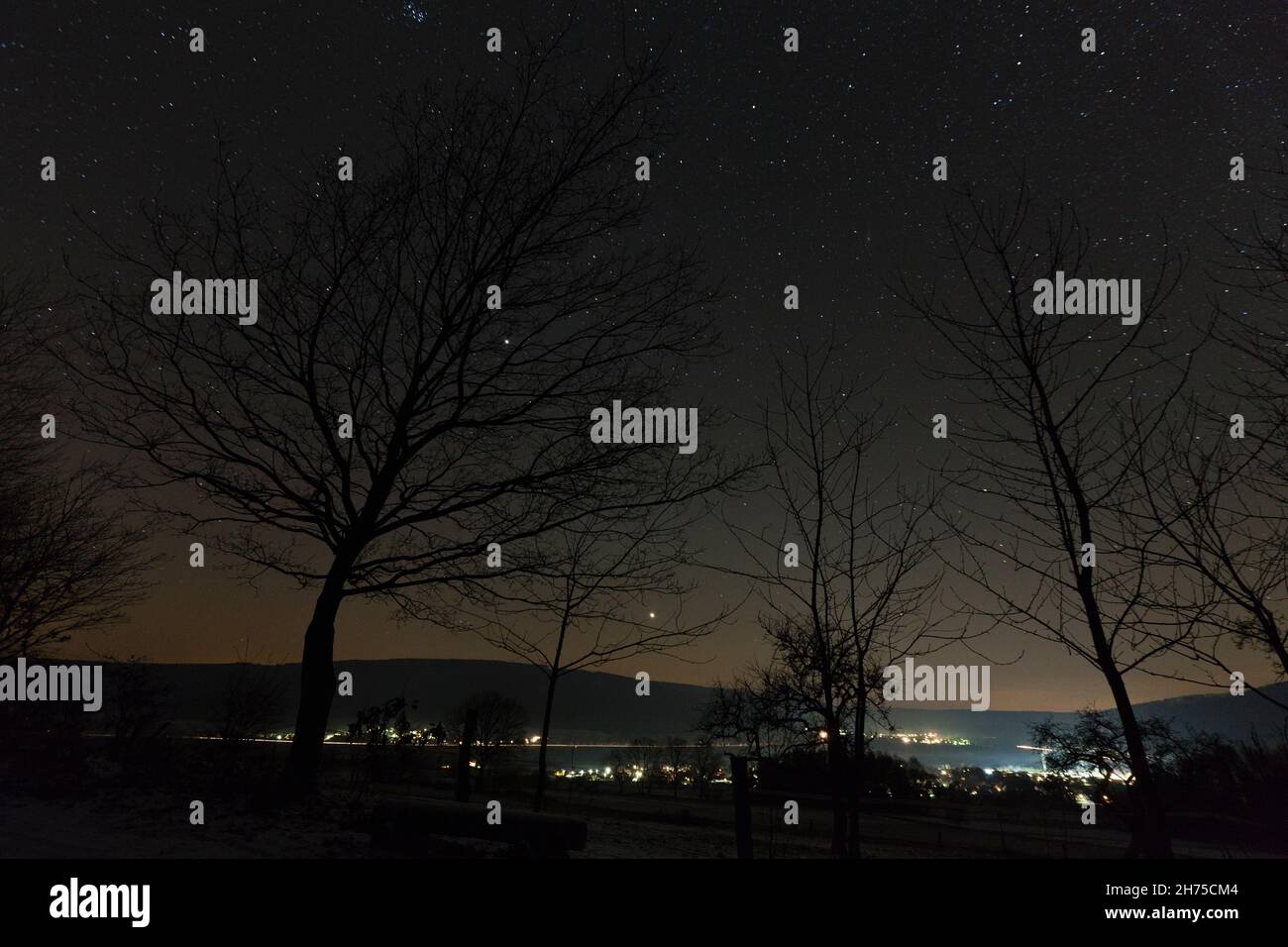 Cielo notturno in inverno, con stelle e luci urbane, bassa Sassonia, Germania Foto Stock