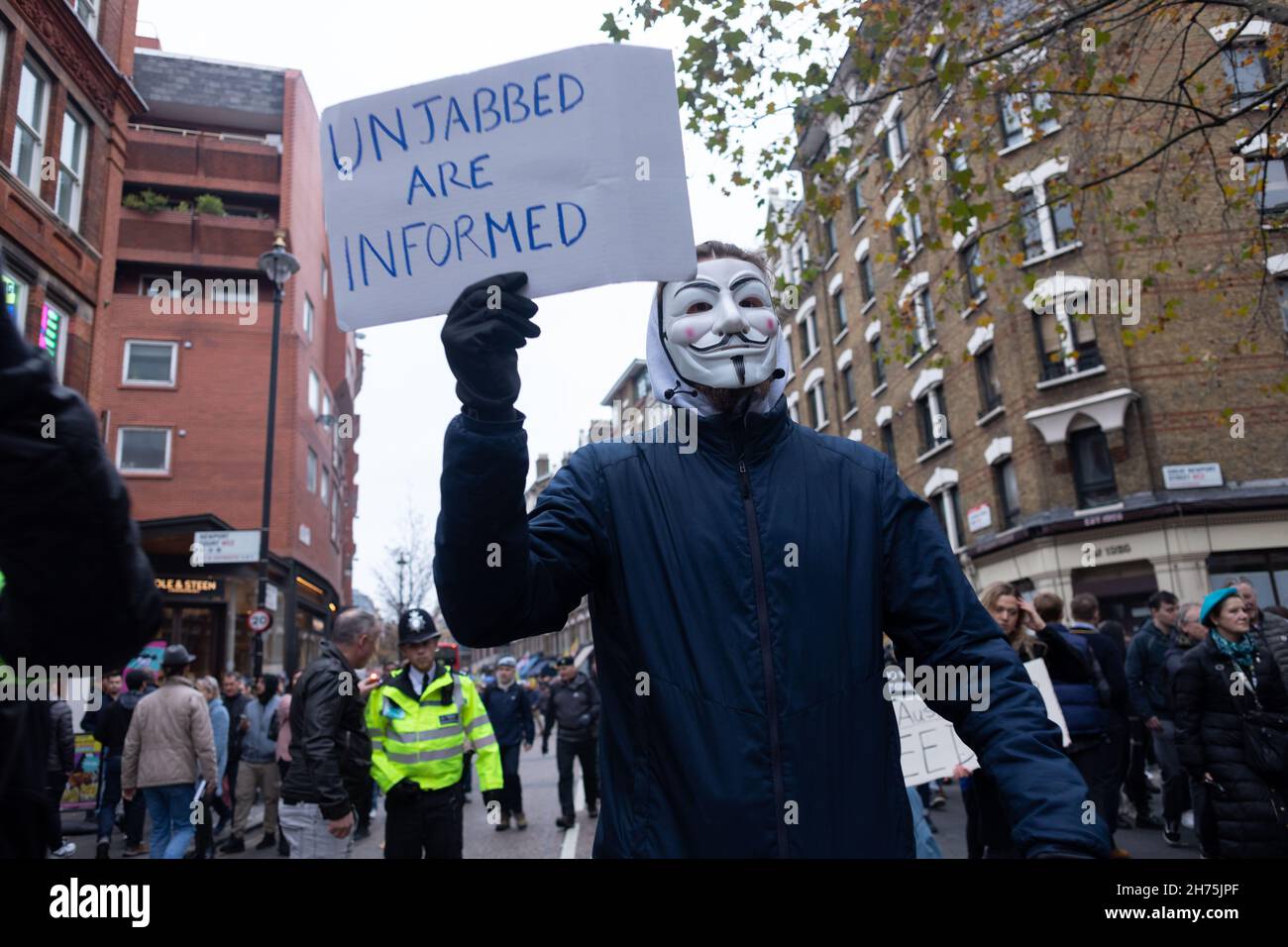 Londra, Regno Unito. 20 Nov 2021. Un protestore che indossa la maschera anonima visto con un segno che dice Unjabbed sono informati durante la dimostrazione.chiamato da StandupX, anti-vaxxers riuniti a Londra come parte del World Wide rally per il movimento di libertà. Il gruppo protesta contro i vaccini COVID obbligatori e l'implementazione di identificazioni di vaccini e passaporti. Credit: SOPA Images Limited/Alamy Live News Foto Stock