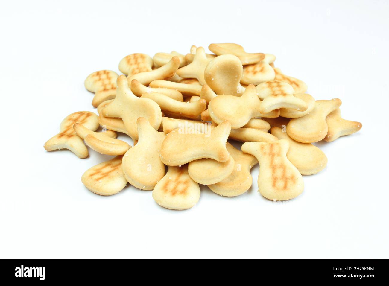 Mucchio di cracker salati isolati su sfondo bianco. Spuntino a forma di pesce Foto Stock