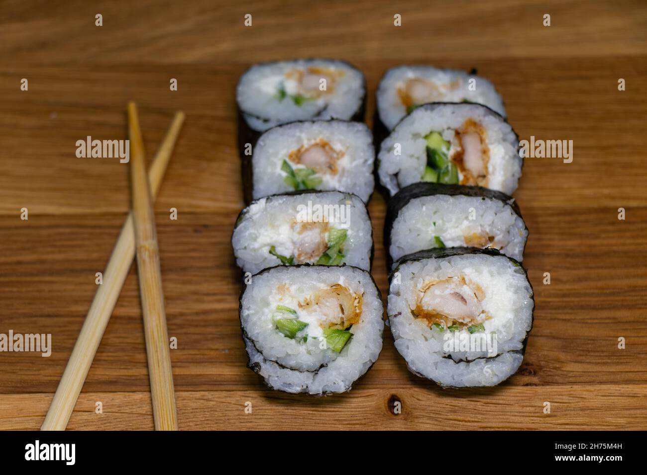 Sushi giapponese su sfondo di legno. Maki Sands Rolls con tonno, pollo, avokado e cetriolo Foto Stock