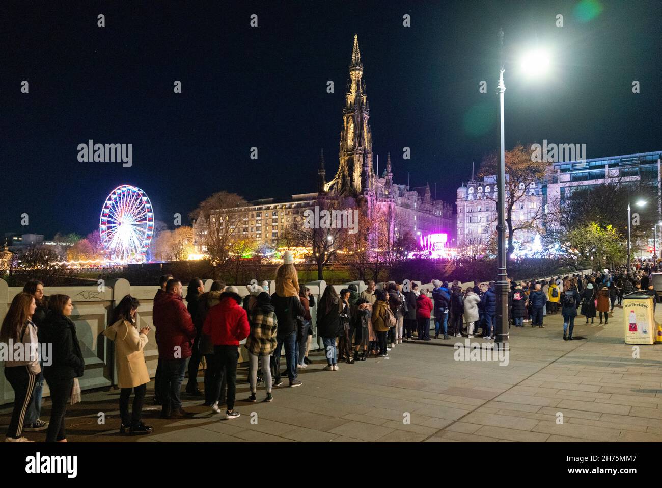 Edimburgo, Scozia, Regno Unito. 20 novembre 2021. Il giorno di apertura del tradizionale mercatino di Natale nei giardini di East Princes Street a Edimburgo ha visto migliaia di visitatori in fila per un massimo di 30 minuti per ottenere l'ingresso. Il mercato è molto più piccolo rispetto agli anni precedenti e il sovraffollamento era una preoccupazione. PIC; lunghe code di visitatori in attesa di entrare nel mercato di Natale. Iain Masterton/Alamy Live News. Foto Stock