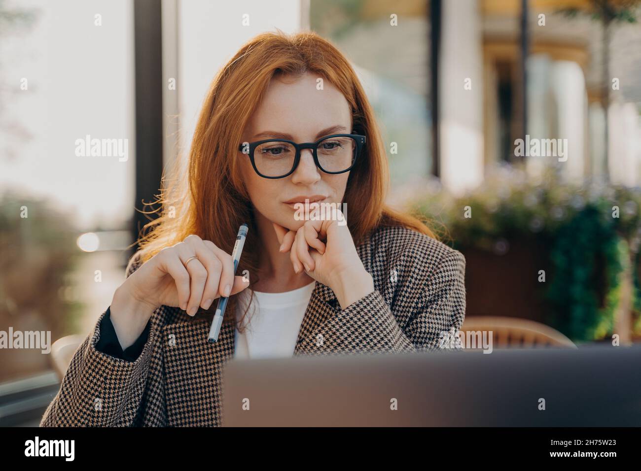 Donna d'affari con esperienza in abiti eleganti guarda il video sulla creazione di startup Foto Stock