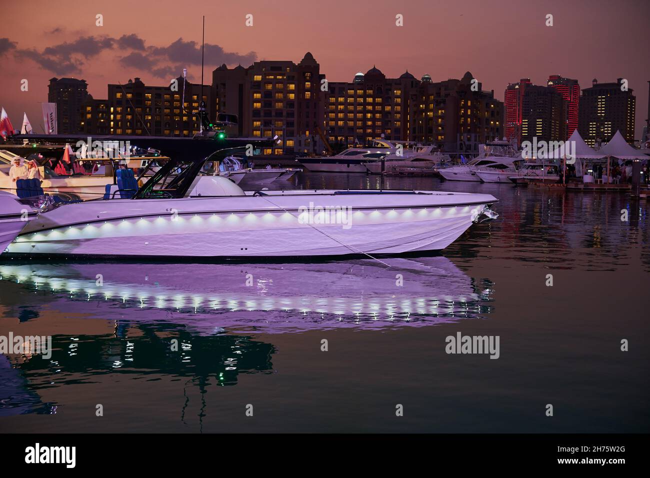 La perla Marina di Porto Arabia vista notturna con barche in primo piano, edifici e nuvole nel cielo in background Foto Stock