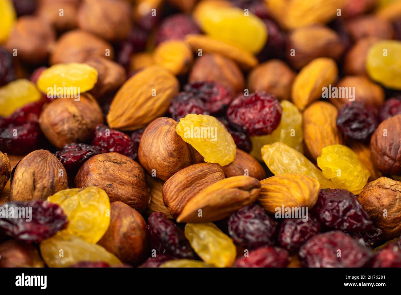 Mix di frutta secca. Spuntini sani. Mandorle, uva passa, nocciole, mirtilli. Noci assortite e bacche secche. Messa a fuoco selettiva, messa a fuoco frontale. H Foto Stock