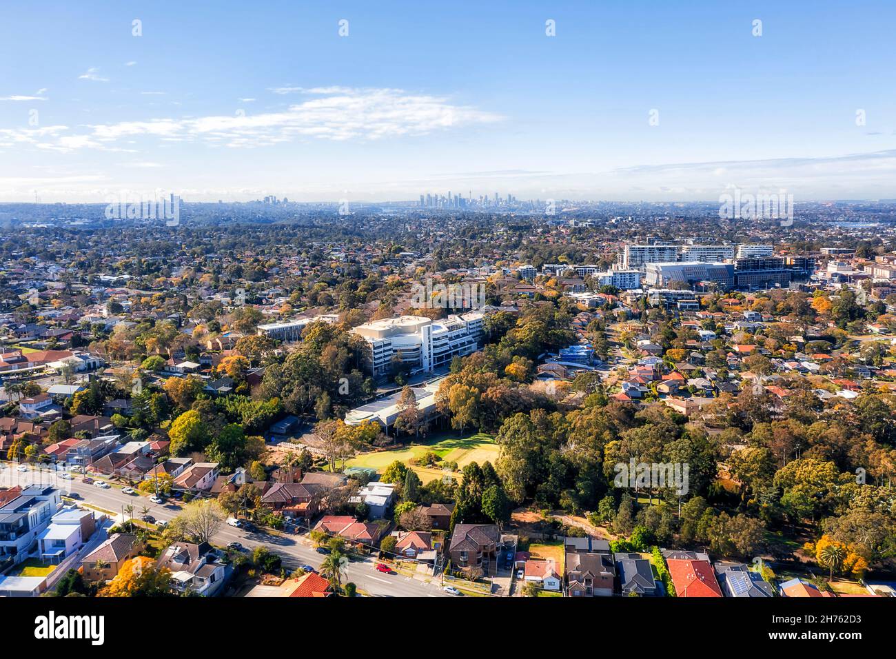 Infinite periferie residenziali e strade verdeggianti a Sydney Ovest dell'Australia - vista aerea verso il CBD della città distante. Foto Stock