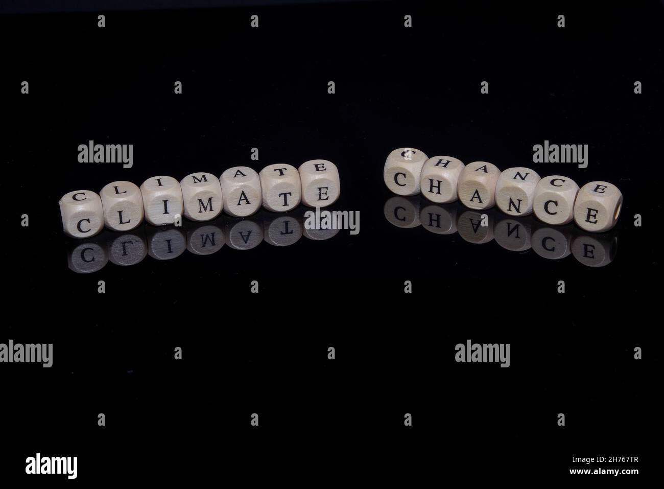 I cubi della lettera formano le parole cambiamento climatico su uno sfondo nero e riflettente Foto Stock