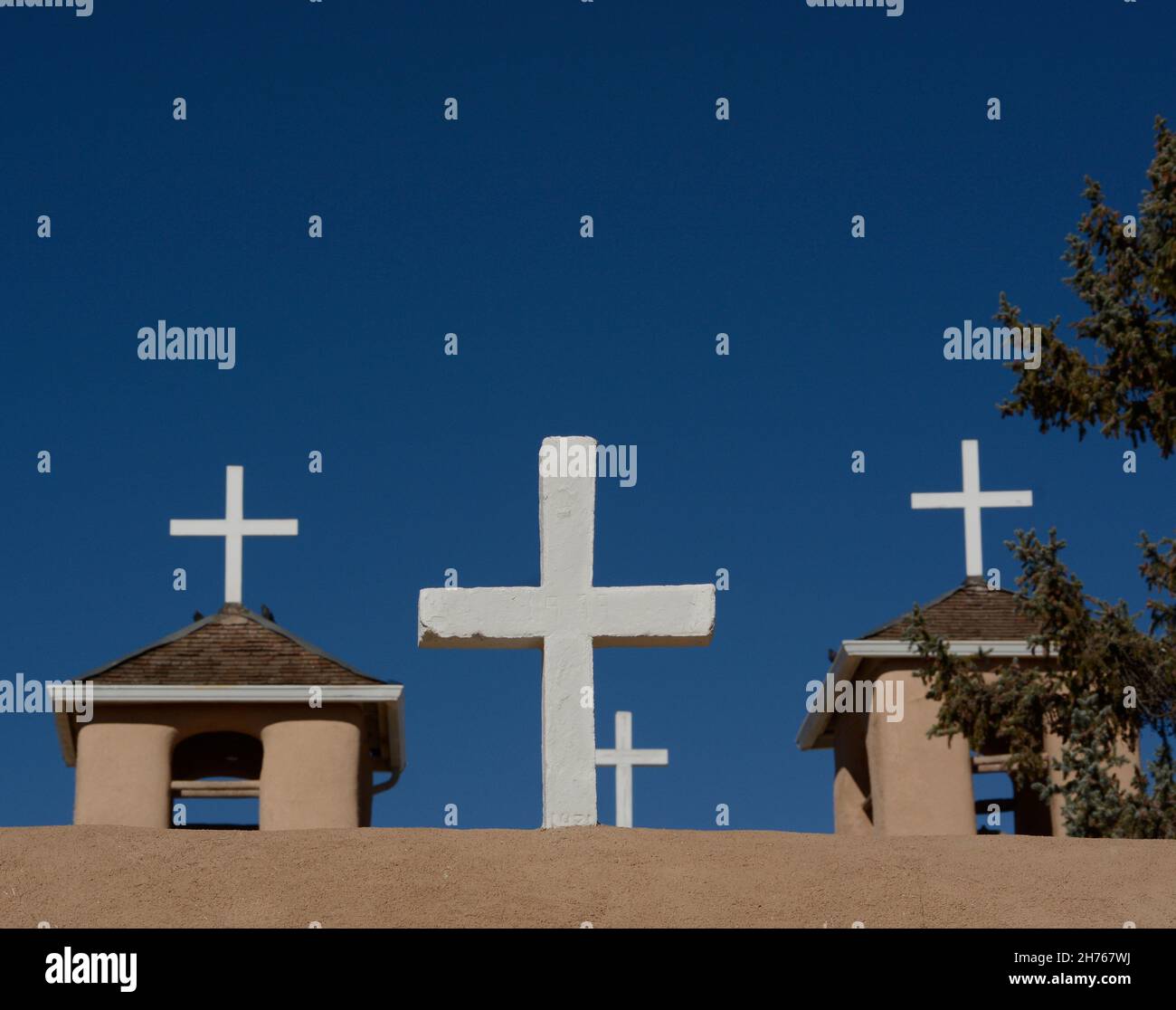 Croci di legno bianco in cima alla storica chiesa della Missione di San Francisco de Asis del XVIII secolo a Rancho de Taos, New Mexico. Foto Stock