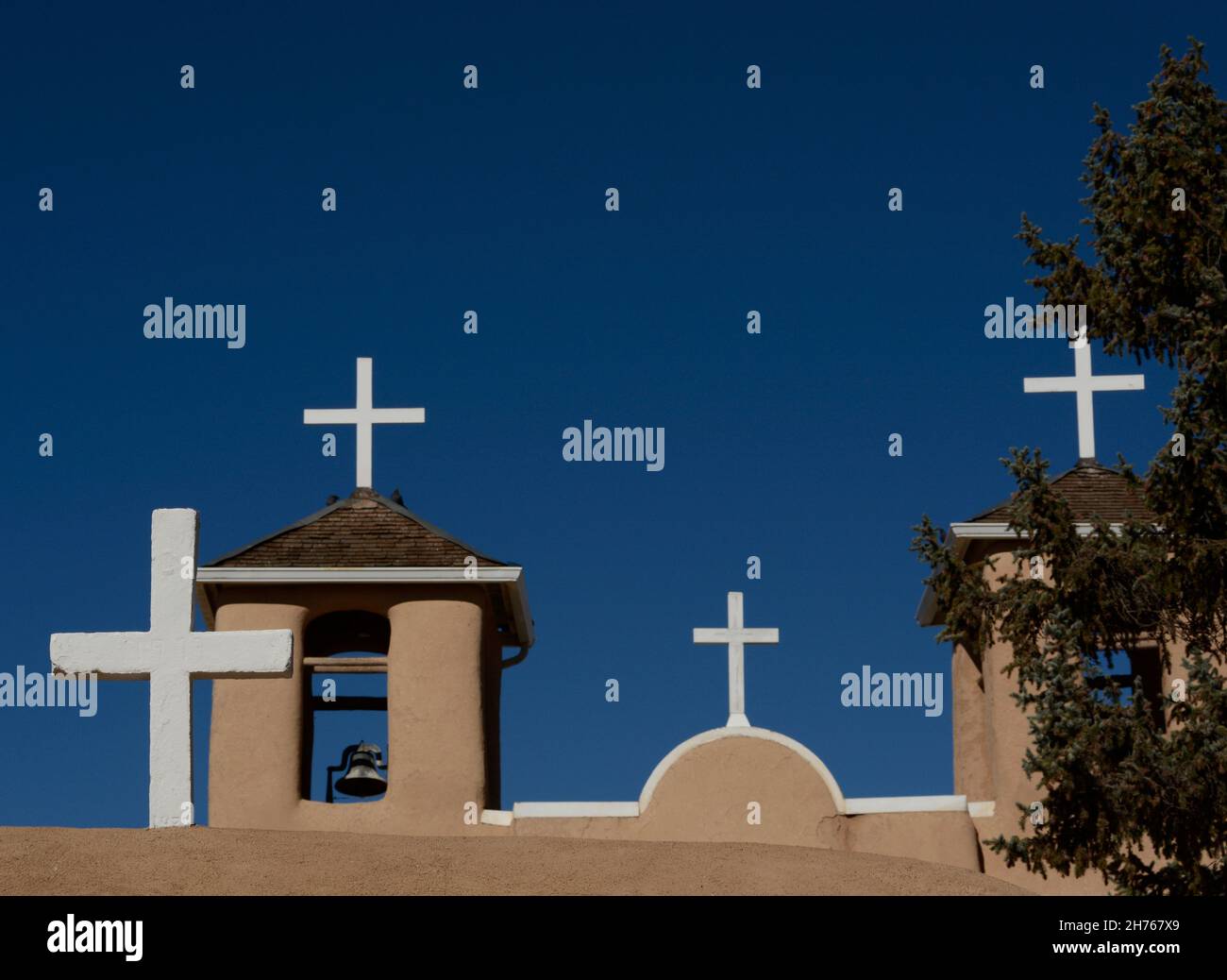 Croci di legno bianco in cima alla storica chiesa della Missione di San Francisco de Asis del XVIII secolo a Rancho de Taos, New Mexico. Foto Stock