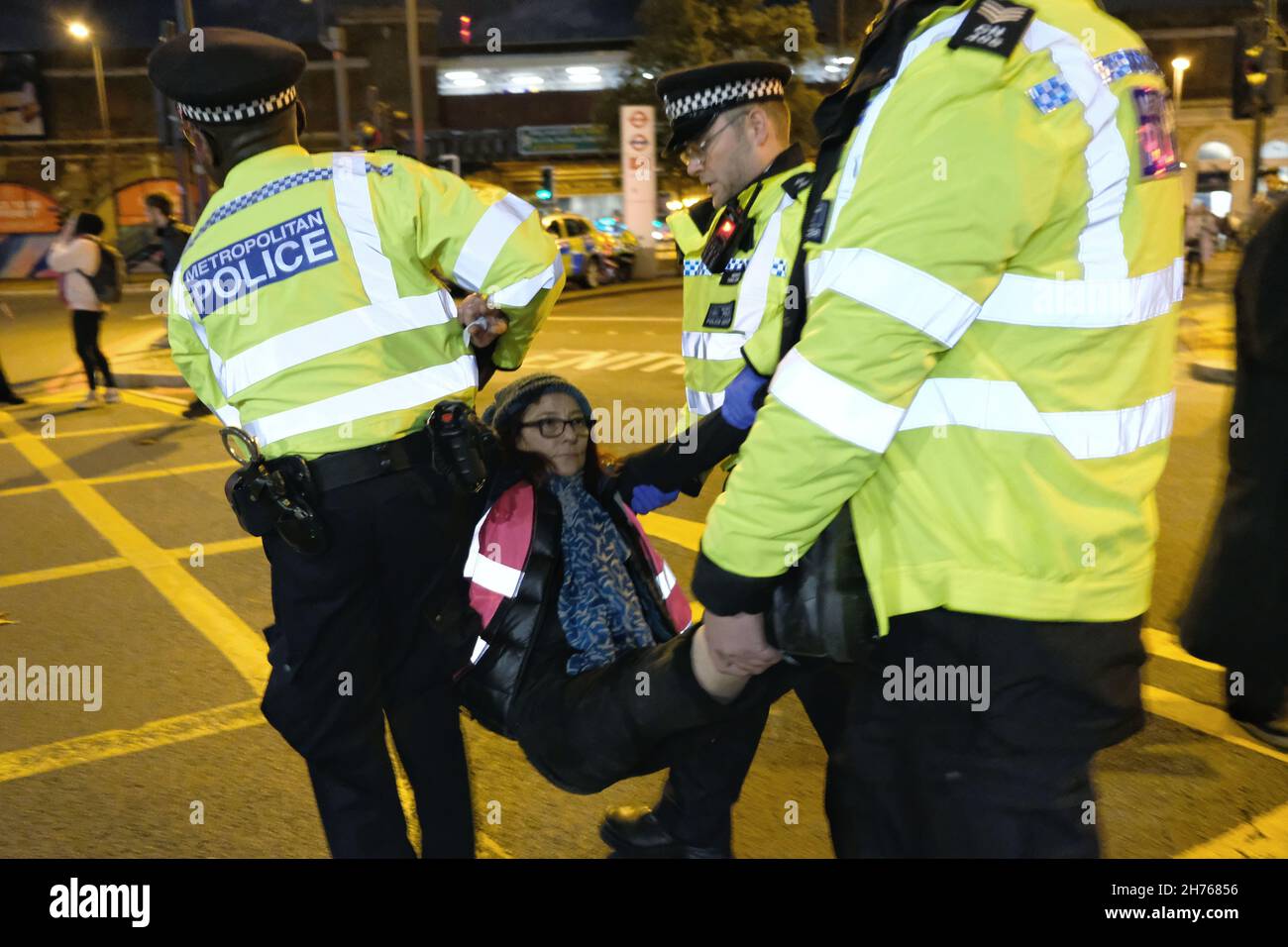 Londra, Regno Unito. 20 novembre 2021, Una donna è portata via dalla polizia durante un isolato blocco stradale britannico a Vauxhall Cross. La manifestazione si è svolta per protestare contro le pene detentive di 3-6 mesi, emesse questa settimana a nove manifestanti per aver violato un'ingiunzione giudiziaria. Isola la Gran Bretagna chiede al governo di finanziare l’isolamento per tutte le abitazioni sociali entro il 2025, al fine di ridurre le emissioni di serra e porre fine alla povertà dei combustibili. Credit: Undicesima ora Fotografia/Alamy Live News Foto Stock