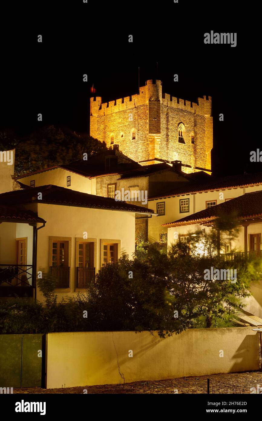 Bragana, Portogallo - 26 giugno 2021: Castello di Bragana in Portogallo, illuminato di notte, con case della cittadella in primo piano. Foto Stock