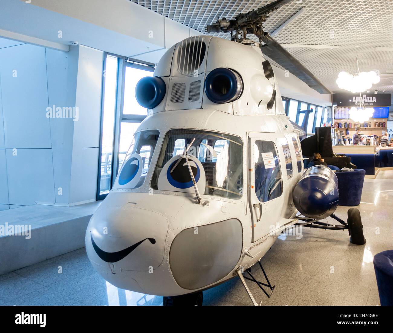 Caffè all'aeroporto con un elicottero sorridente modello a grandezza naturale nell'aeroporto nazionale di Minsk, Bielorussia Foto Stock