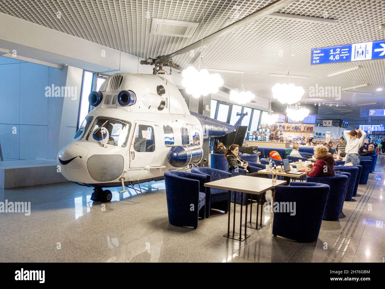 Caffè all'aeroporto con un elicottero sorridente modello a grandezza naturale nell'aeroporto nazionale di Minsk, Bielorussia Foto Stock