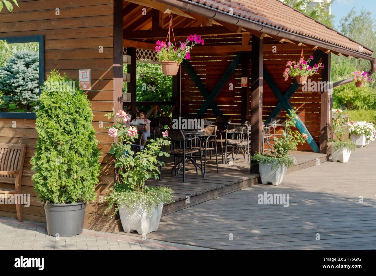 Una veranda in legno aperta dove potrete mangiare il vostro cibo nel parco Garden of Dreams in una giornata estiva soleggiata. Foto Stock