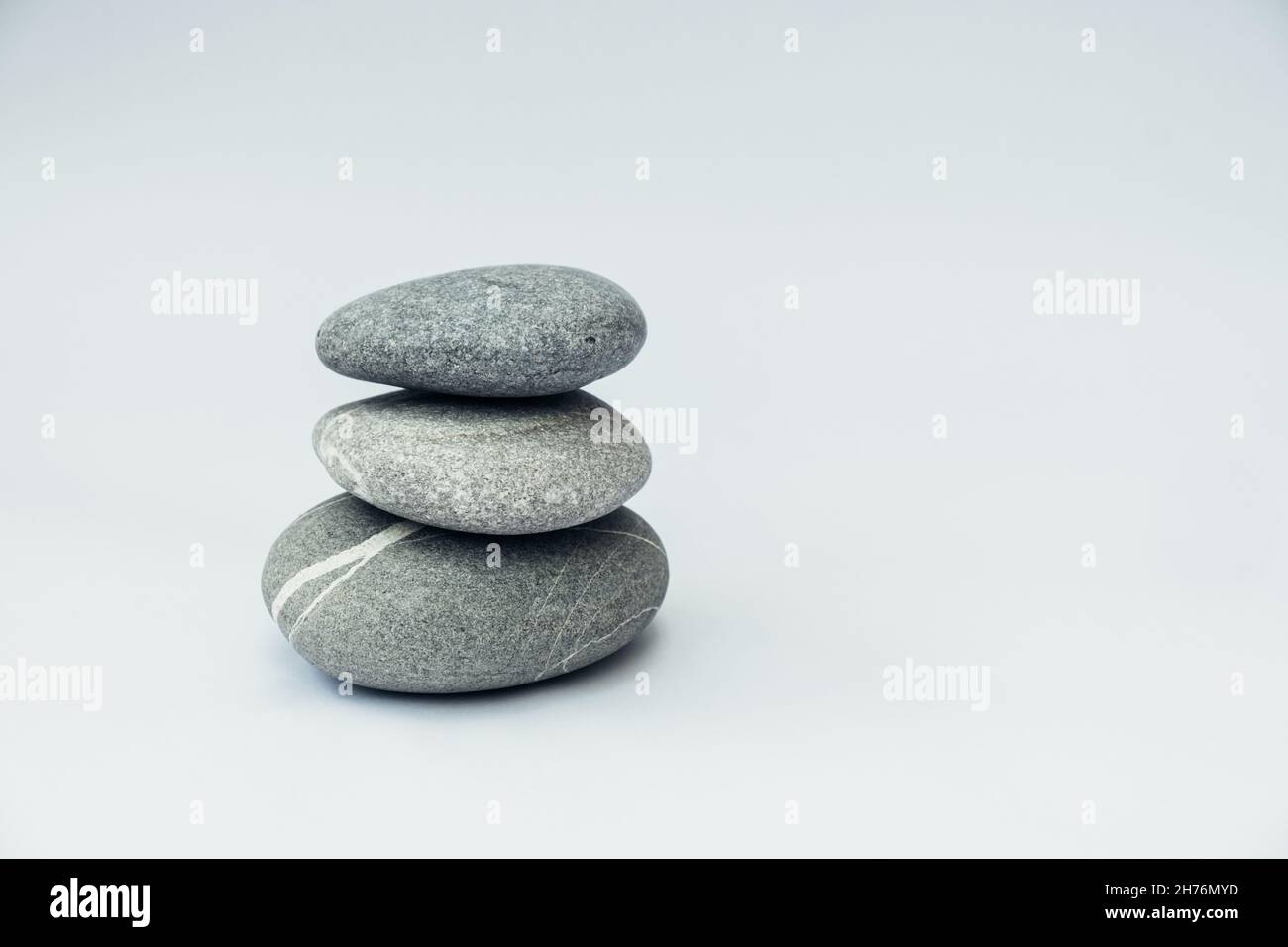 Pietra cairn su sfondo chiaro, pietra torre, semplici poise pietre. Purezza armonia ed equilibrio concetto. Foto Stock