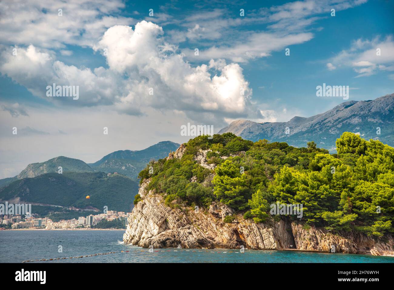 Bei sentieri alberati che corrono a nord da Sveti Stefan Island, oltre il mare blu e le località turistiche, punteggiato lungo la costa adriatica. Foto Stock