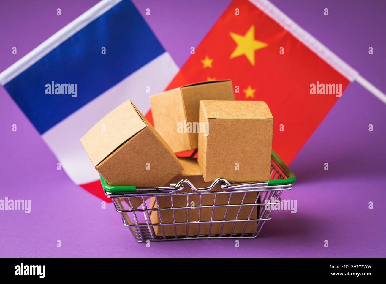 Scatole in un cestino di cibo e bandiere di Cina e Francia su uno sfondo colorato, il concetto di commercio tra paesi Foto Stock