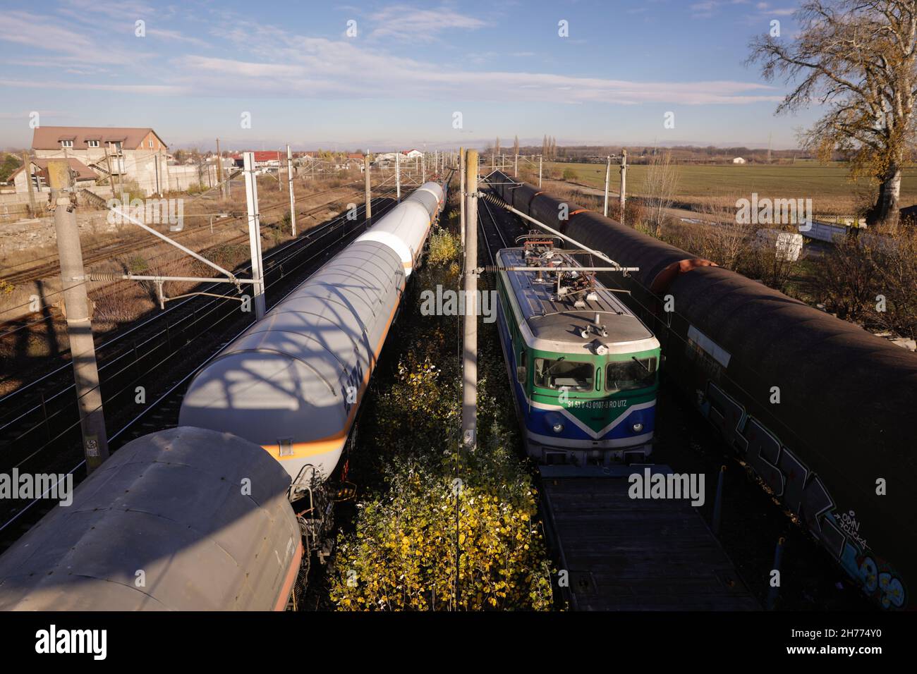 Buftea, Romania - 20 novembre 2021: Locomotiva del treno merci e vagoni petroliferi in una stazione. Foto Stock