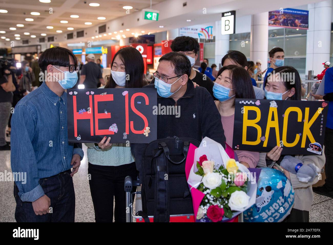 Sydney, Australia. 21 Nov 2021. Le persone accolgono i passeggeri da Singapore all'Aeroporto di Sydney, Sydney, Australia, il 21 novembre 2021. La bolla di viaggio australiana con Singapore è entrata in vigore domenica. Credit: Bai Xuefei/Xinhua/Alamy Live News Foto Stock