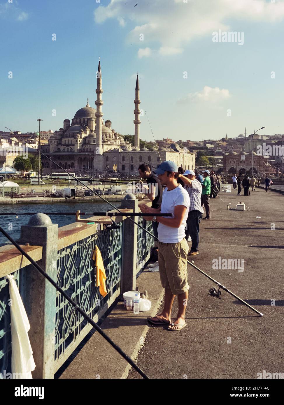 Vita quotidiana a Istanbul pescatori sul ponte Galata sullo sfondo Yeni Moschea, Turchia Foto Stock