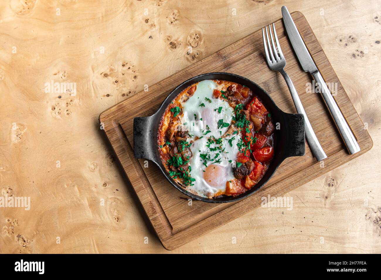 Shakshuka in pentola di asciugatura. Uova in camicia con salsa piccante di pepe di pomodoro. Foto Stock