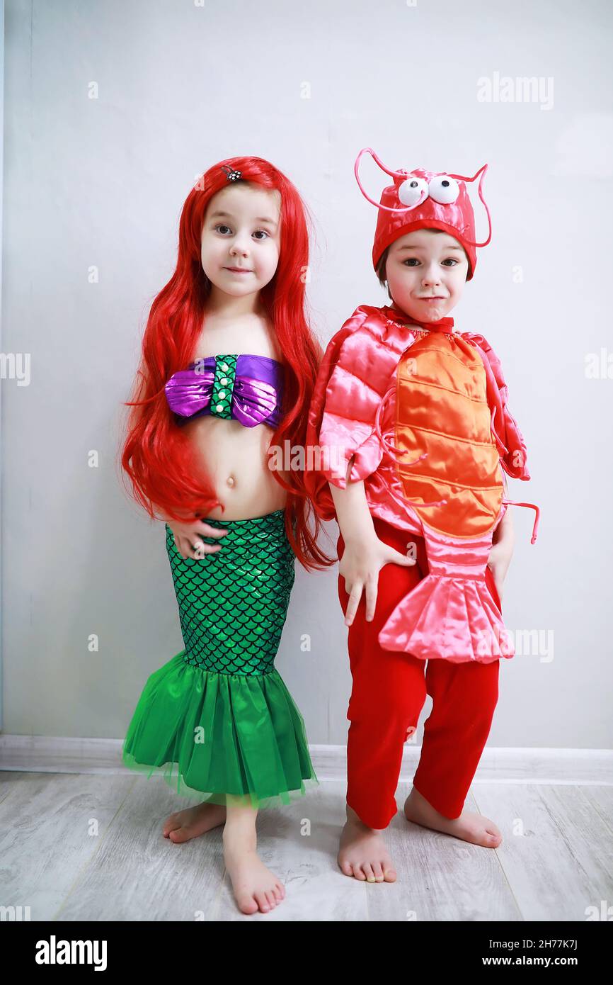 Bambini in eleganti costumi di carnevale su uno sfondo semplice. Costume di  creature fata di mare. Sirena e granchio. Fratello e sorella Foto stock -  Alamy