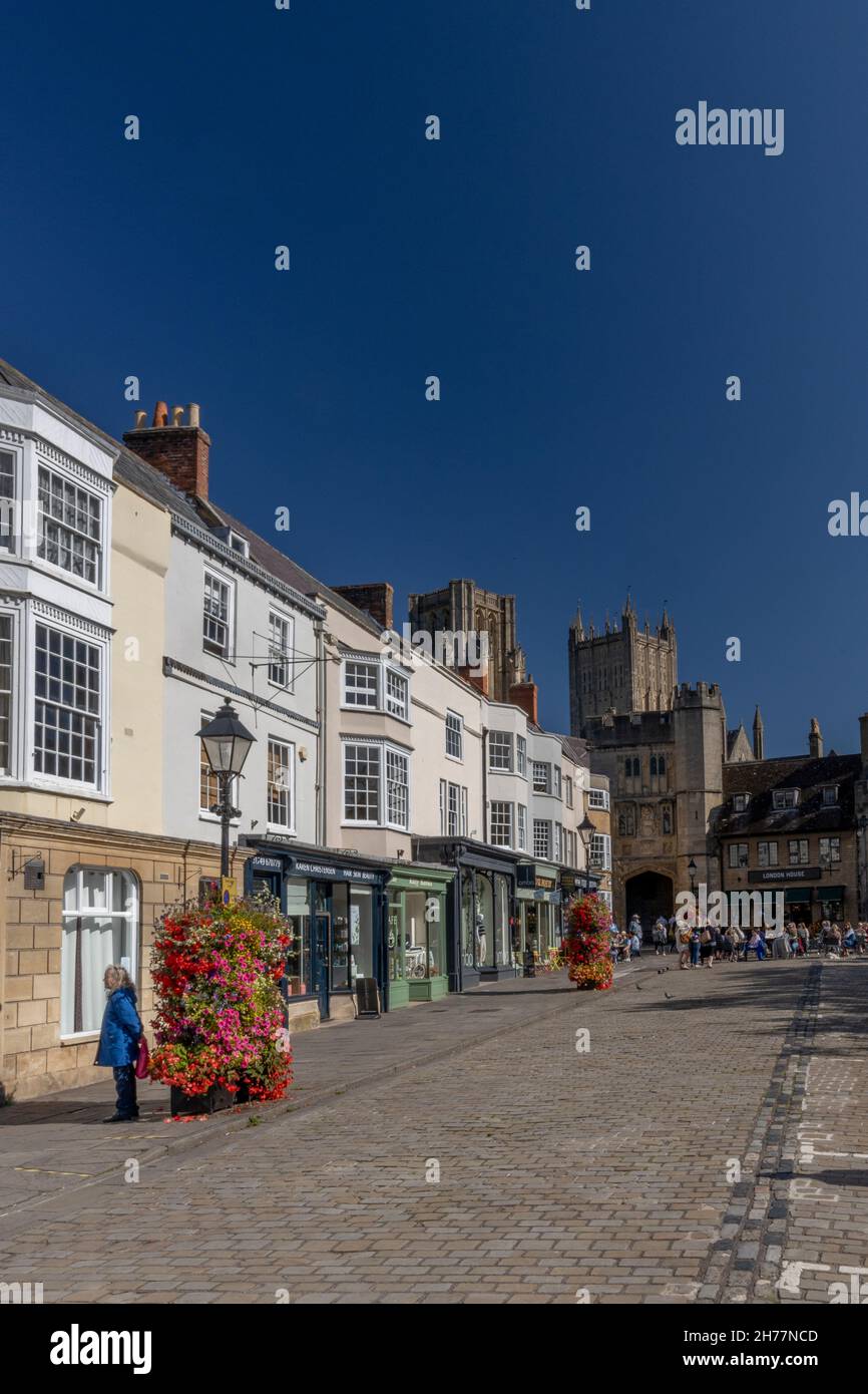 Il mercato acciottolato, la cattedrale e le esposizioni floreali a Wells, Somerset, Inghilterra, Regno Unito Foto Stock