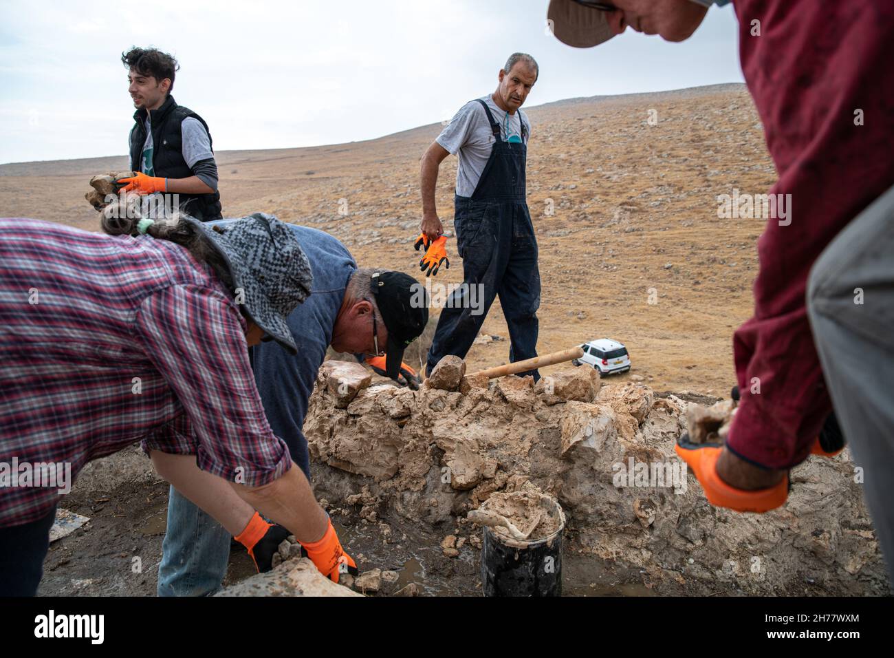 Riabilitazione di antiche fabbriche d'acqua utilizzate da pastori palestinesi locali dall'organizzazione attivista israeliana "Guerrieri per la Pace", il giorno della prima pioggia nella Valle settentrionale della Giordania. I pozzi sono un'infrastruttura critica nel contesto della scarsità d'acqua e della mancanza di infrastrutture di approvvigionamento idrico per le comunità rurali palestinesi dei pastori, i cui pascoli si stanno restringendo a causa dell'espansione dell'insediamento ebraico. La Cisgiordania. Il 19 novembre 2021. ( Matan Golan/Alamy Live News) Foto Stock