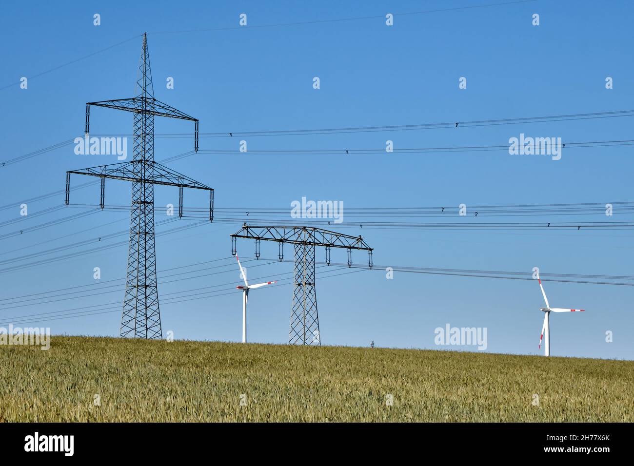 Linee elettriche e turbine eoliche viste nelle zone rurali della Germania Foto Stock