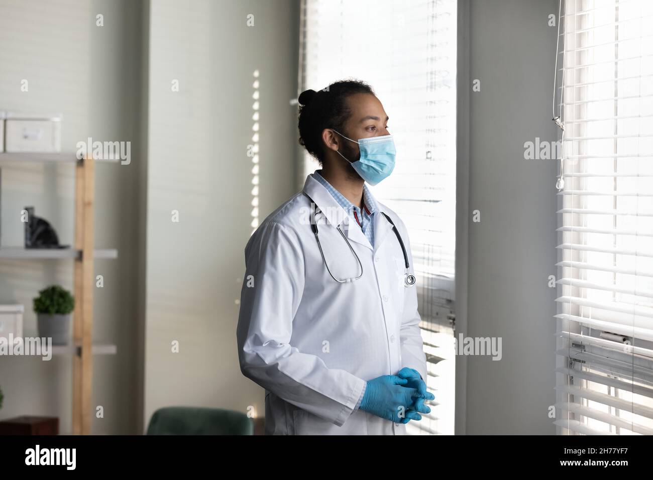 Uomo medico africano americano pensivo indossare maschera medica pensiero Foto Stock